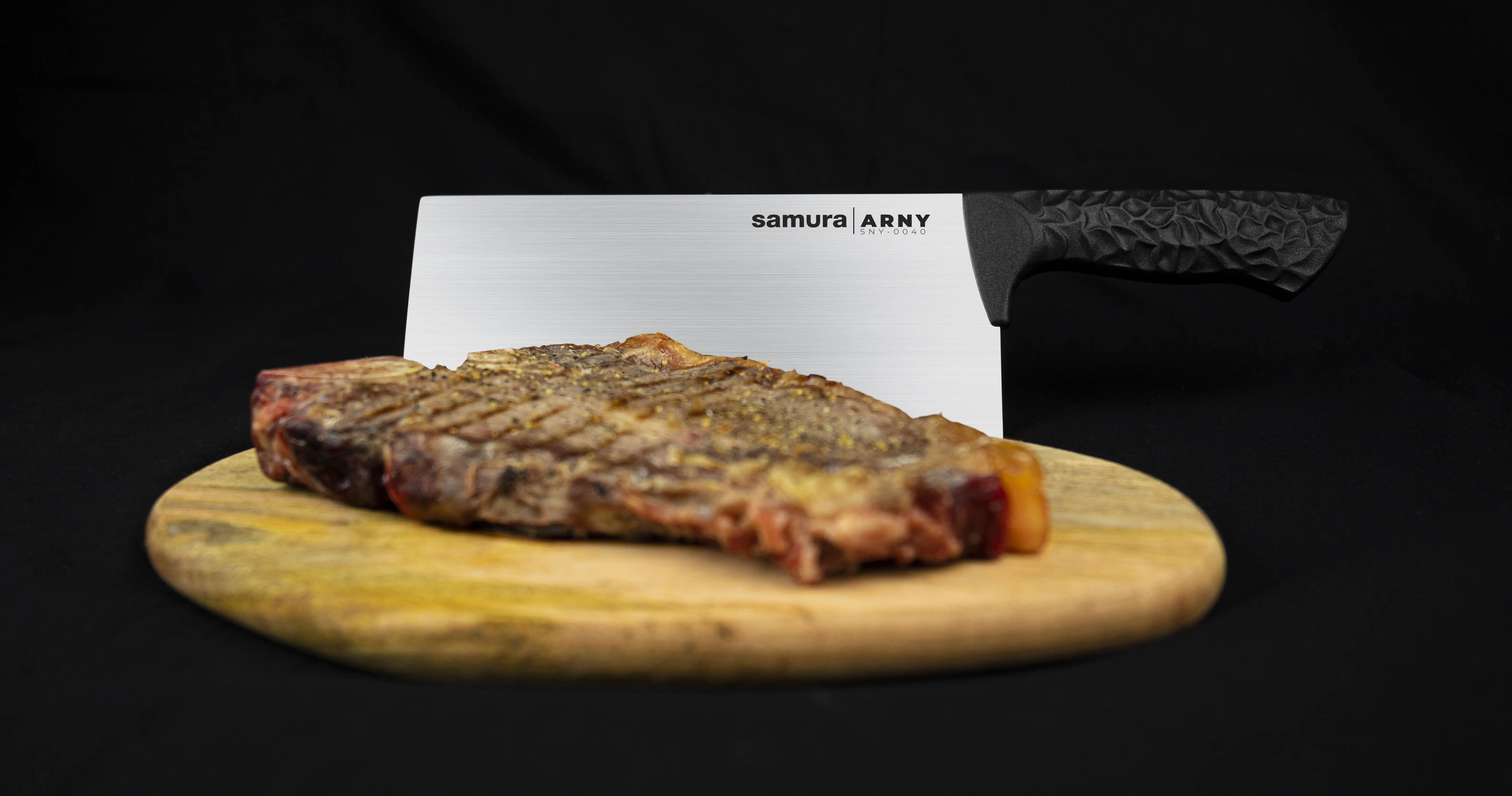 Precision Knives Samura Arny Black Handle on a wooden chopping board behind a steak