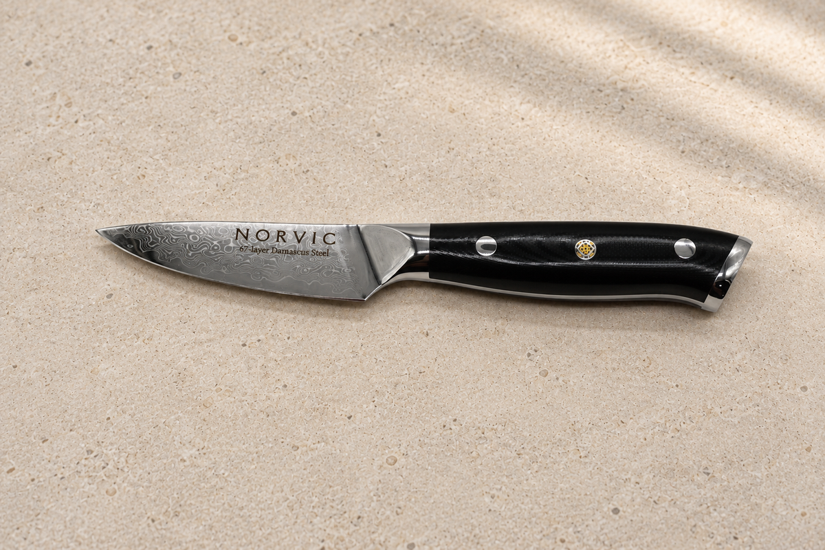 Side profile of the Norvic Worstead 3.5-inch paring knife, showing the Damascus blade and black G10 handle
