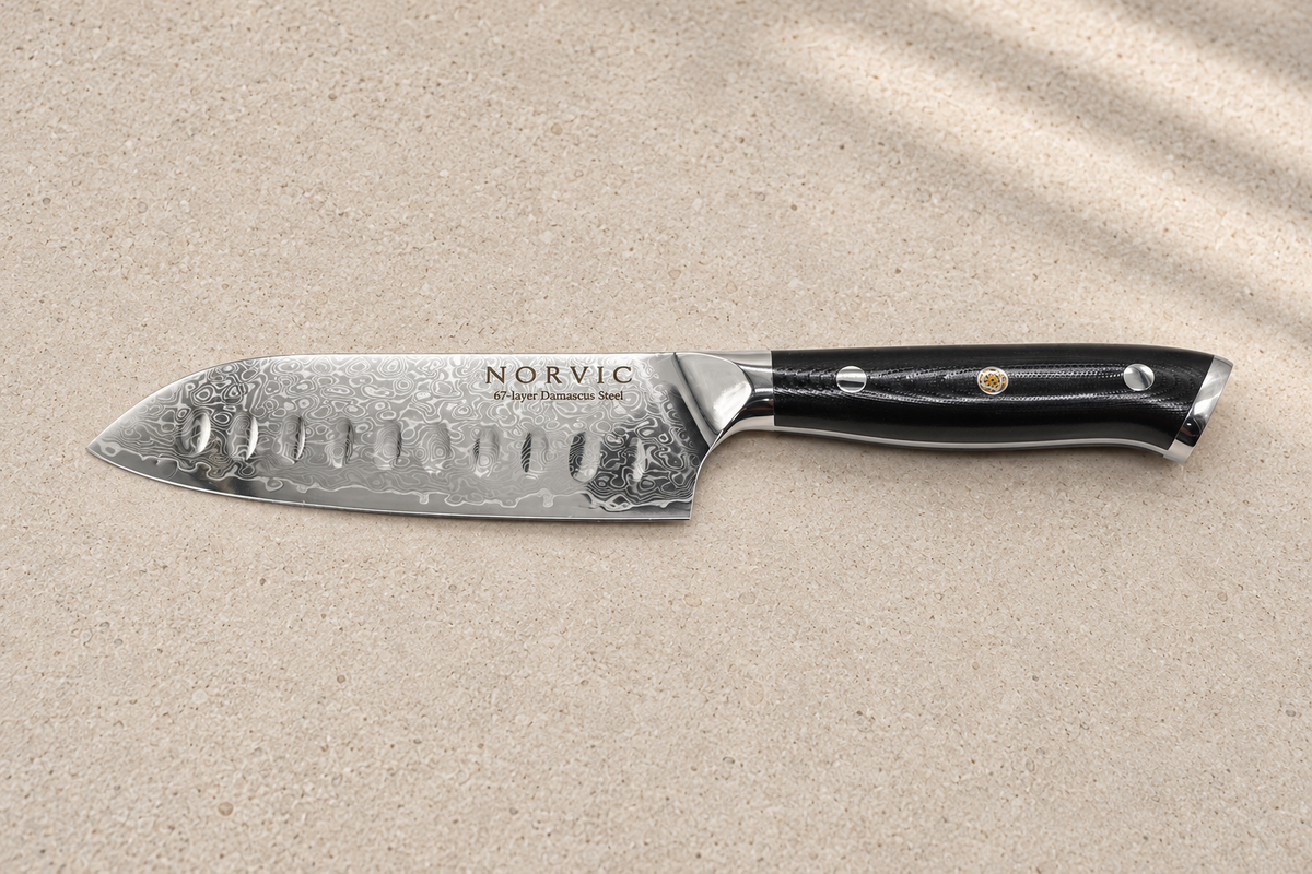 Side profile of the Norvic Worstead 5-inch santoku knife, showing its dimpled Damascus blade and black G10 handle
