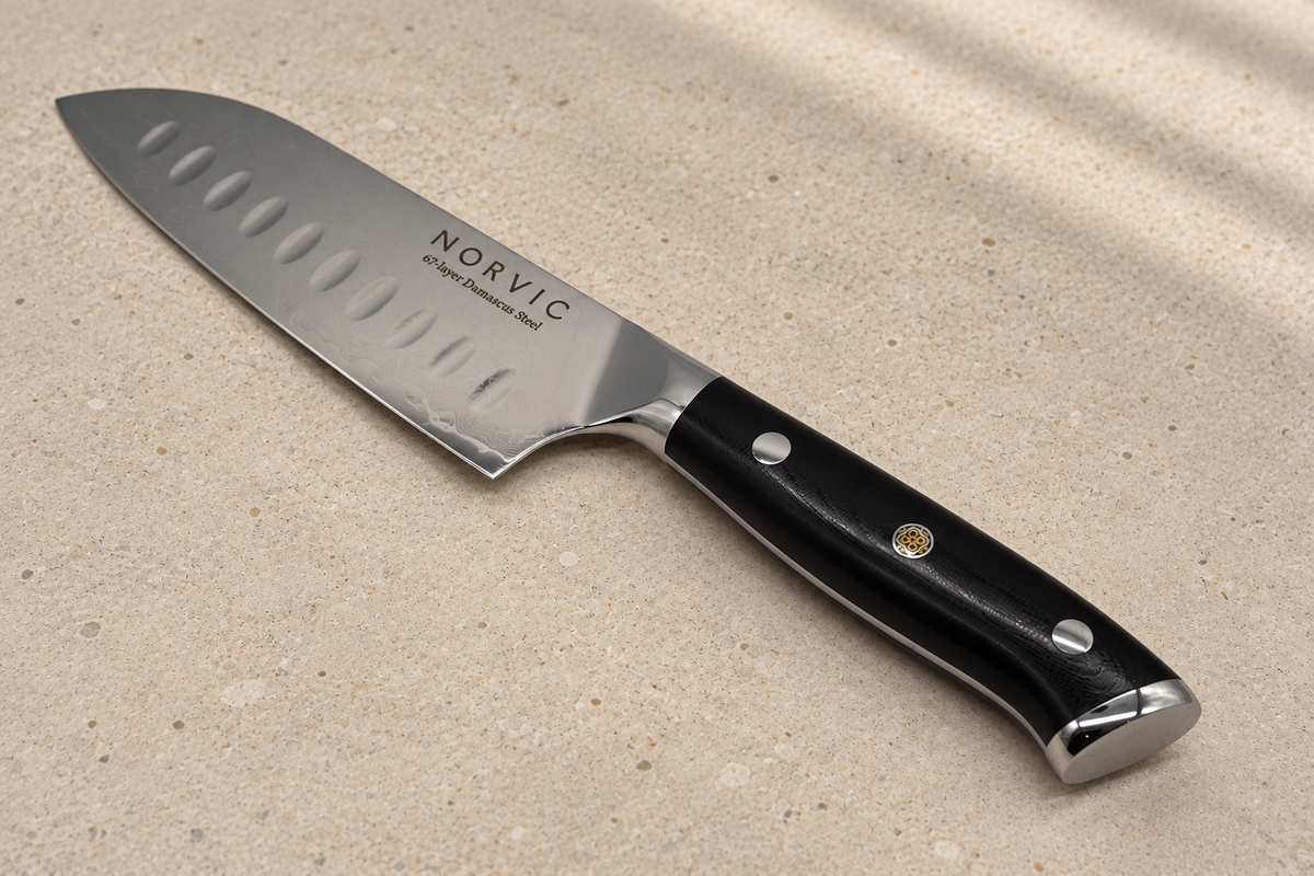 Closer view of the Norvic Worstead 5-inch santoku knife, showing the black G10 handle, mosaic pin, bolster and Norvic engraving