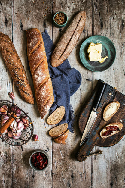 Precision Knives Samura Damascus utility Knife next to loaf of bread