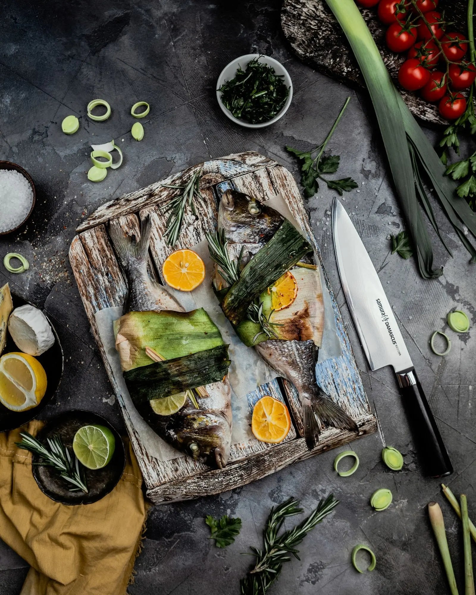 Precision Knives Samura Damascus Knife next to chopping board with fish on