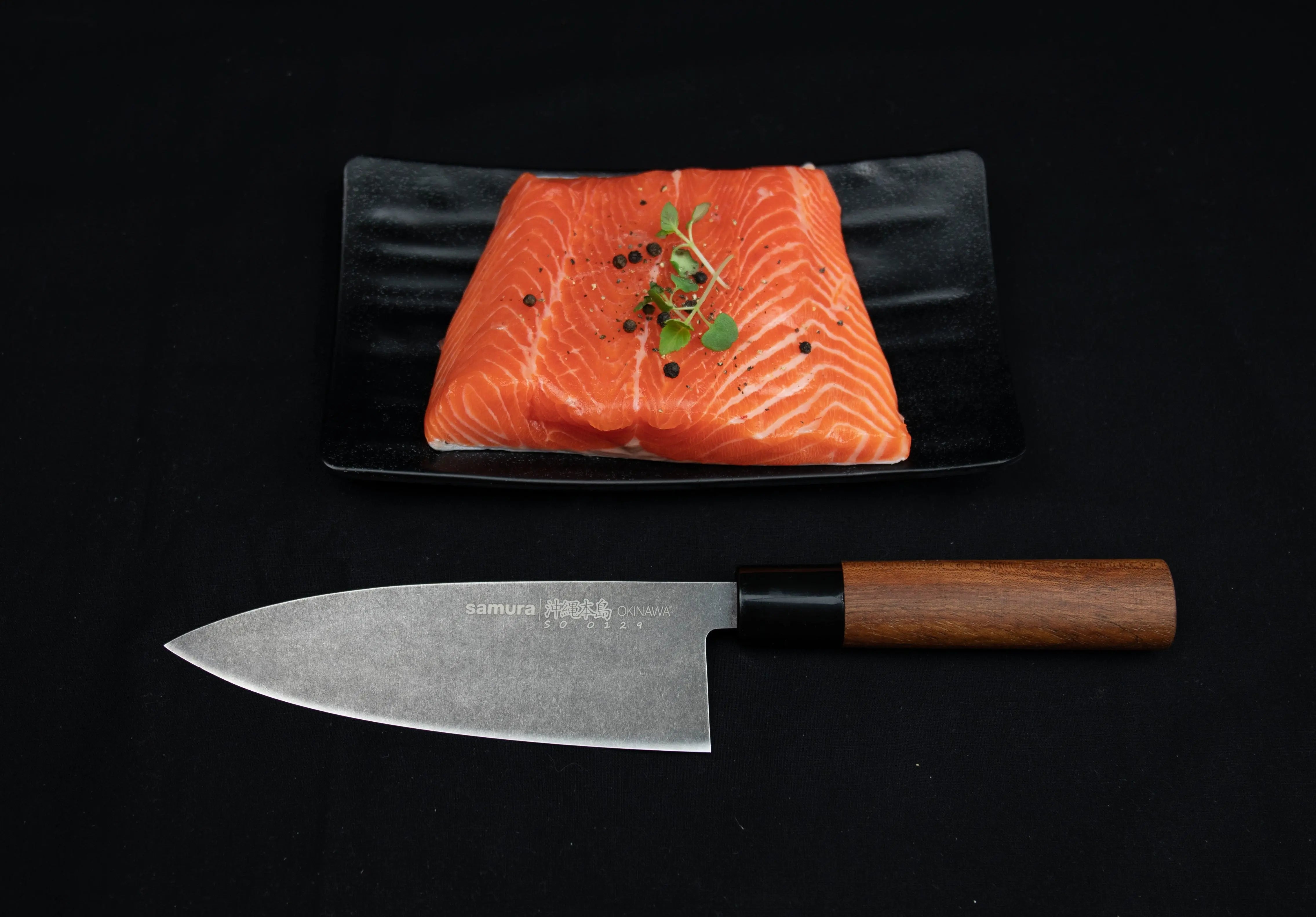 Precision Knives Samura Okinawa Stonewashed Deba next to plate of salmon
