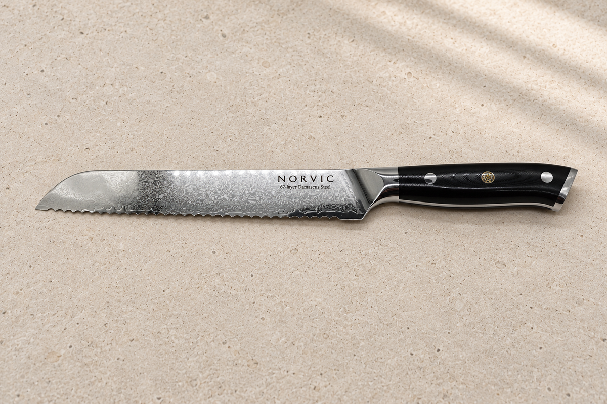 Side profile of the Norvic Worstead 8-inch bread knife, showing its serrated Damascus blade and black G10 handle